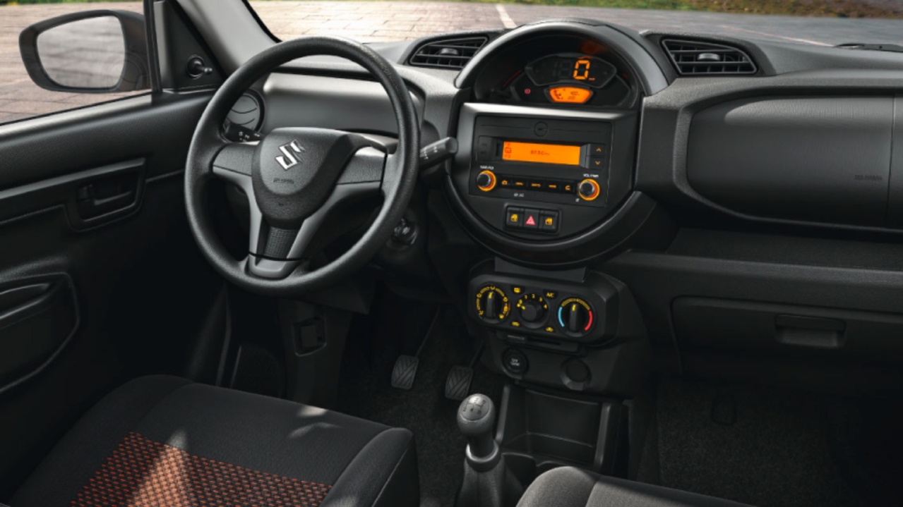 Vista interior de Suzuki S-presso con caja de cambios mecanicamecánica y con vista a montañas.